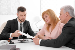 Three professionals discussing documents in an office.